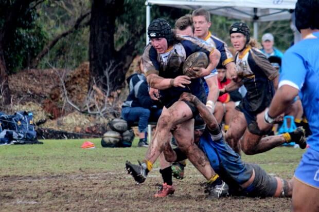 Lachlan Lonergan takes the ball up in the mud