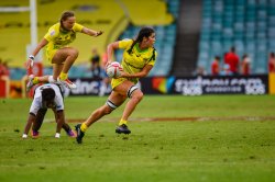 Charlotte Caslick looks for support as Emma Sykes hurdles a Fijian player