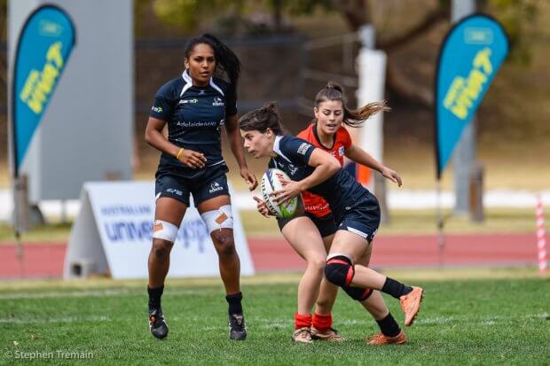 Mahalia Murphy watches on as Lauren Kildare beats a tackle of a University of Tasmania player