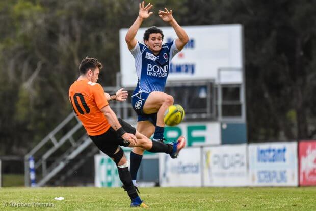 Izaia Perese attempts a charge-down of Tayler Adams' kick