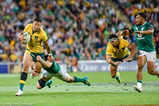 Israel Folau struggles to beat a tackle as Kurtley Beale hits the deck